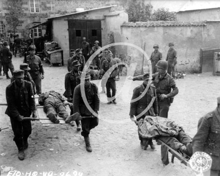 BREHAL(50290) Seconde guerre mondiale Des prisonniers allemands transportent leurs camarades morts au cimetire de Brhal sous la surveillance de soldats amricains.
