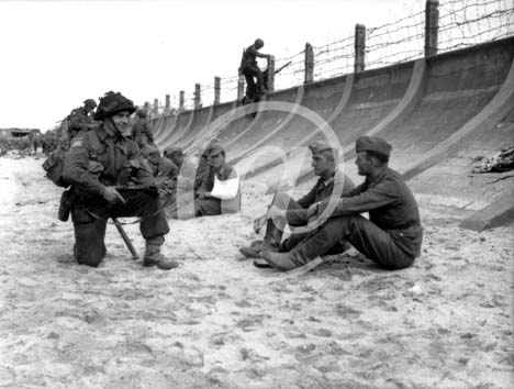 BERNIERES SUR MER(14990) 6 juin 1944 Un soldat canadien interroge accroupis deux prisonniers allemands capturs par les troupes canadiennes  Juno Beach le D Day. D