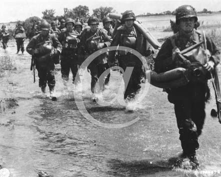 UTAH BEACH(50480) Seconde guerre mondiale Des troupes amricaines avec tous leurs paquetages marchent dans un marais.
