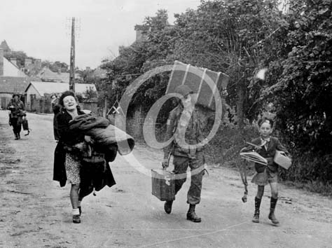 SAINTE MERE EGLISE(50480) Seconde guerre mondiale Ce parachustiste de la 82nd Division aroporte aide une civile  porter ses paquets.