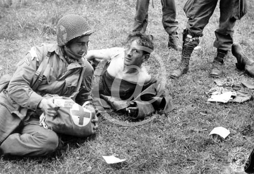 SAINTE MERE EGLISE(50480) Seconde guerre mondiale Un soldat allemand bless aid et soign par des parachustistes de la 82nd Division aroporte.