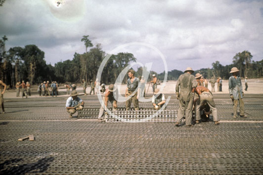 inconnu() Seconde guerre mondiale US Navy en couleurs - Srie 80-GK- : De nombreux soldats US sont affect au posage des plaques metalliques antidrapantes sur une nouvelle piste d