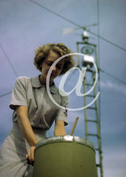 inconnu() Seconde guerre mondiale US Navy en couleurs - Srie 80-GK- : Une femme dans une base aerienne penche sur un bidon de quelquechose.