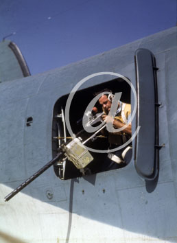 inconnu() Seconde guerre mondiale US Navy en couleurs - Srie 80-GK- : Un mitrailleur pose dans sa carlingue, le doigt sur sa dtente.